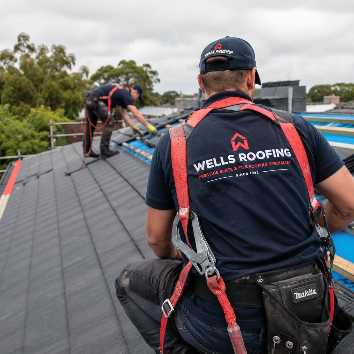 Wells Roofing crew laying natural slate on a re-roof