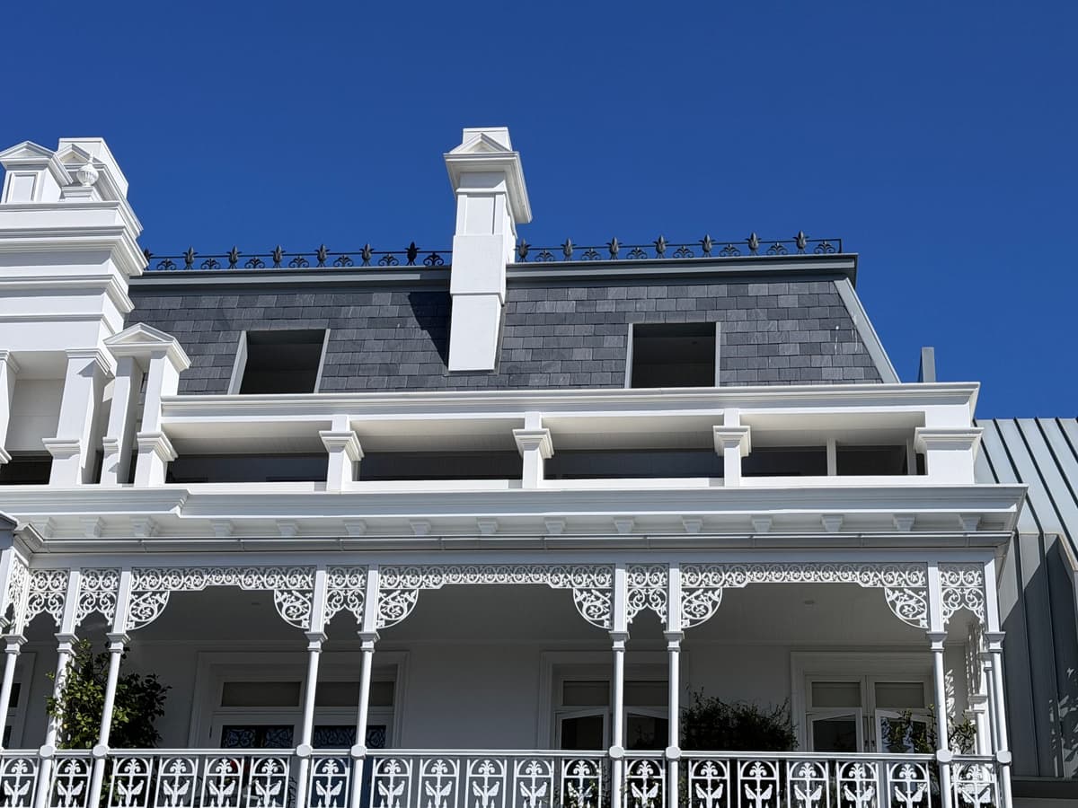 Slate mansard roof and chimney above the cast-iron verandah