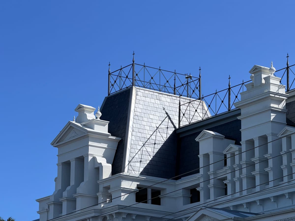 Steep slate mansard roof beneath decorative iron cresting