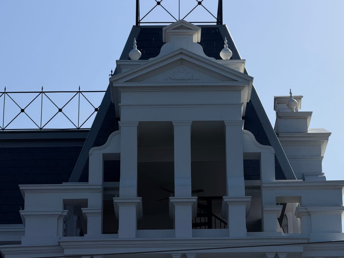 Pedimented dormer set into the slate roof, framed by iron cresting