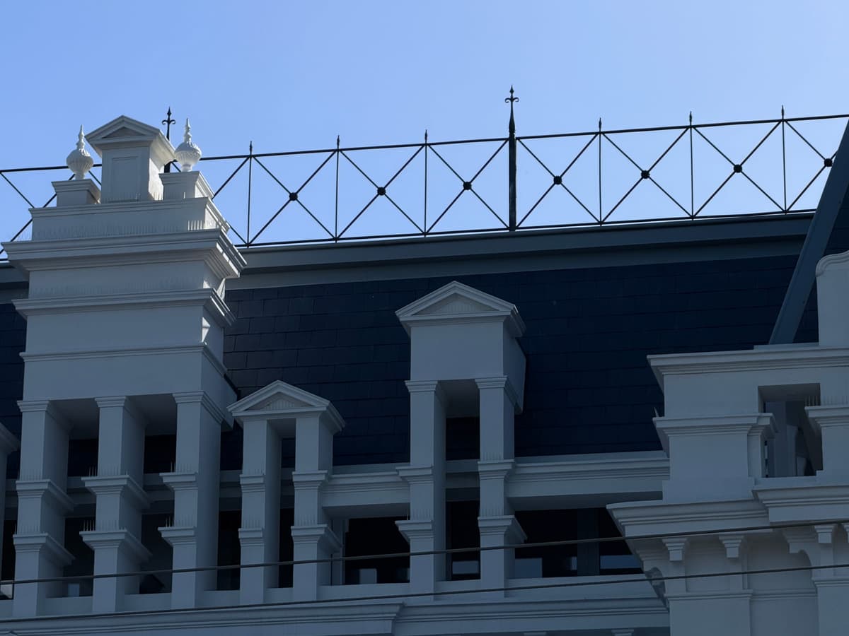 Slate roof behind the parapet dormers and iron cresting