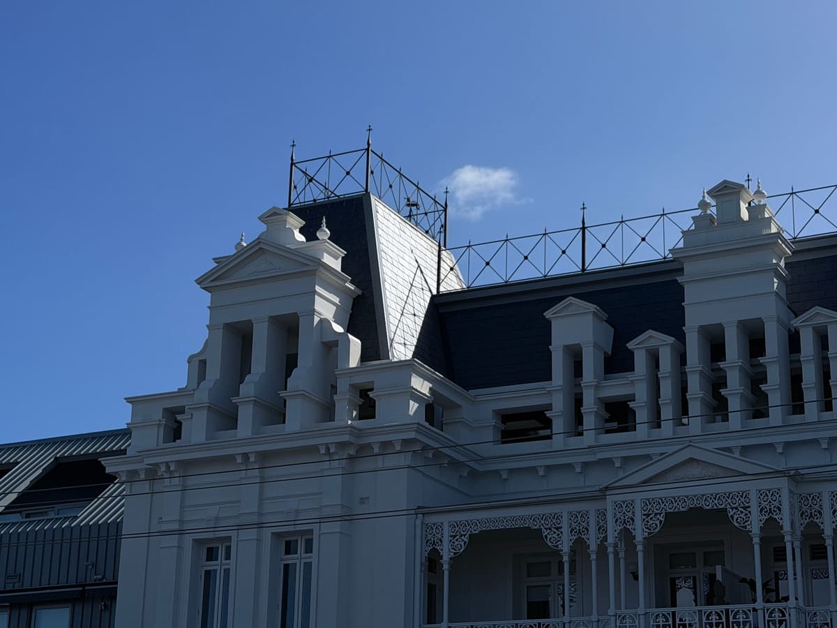 Slate mansard roof and dormers above the corner balcony